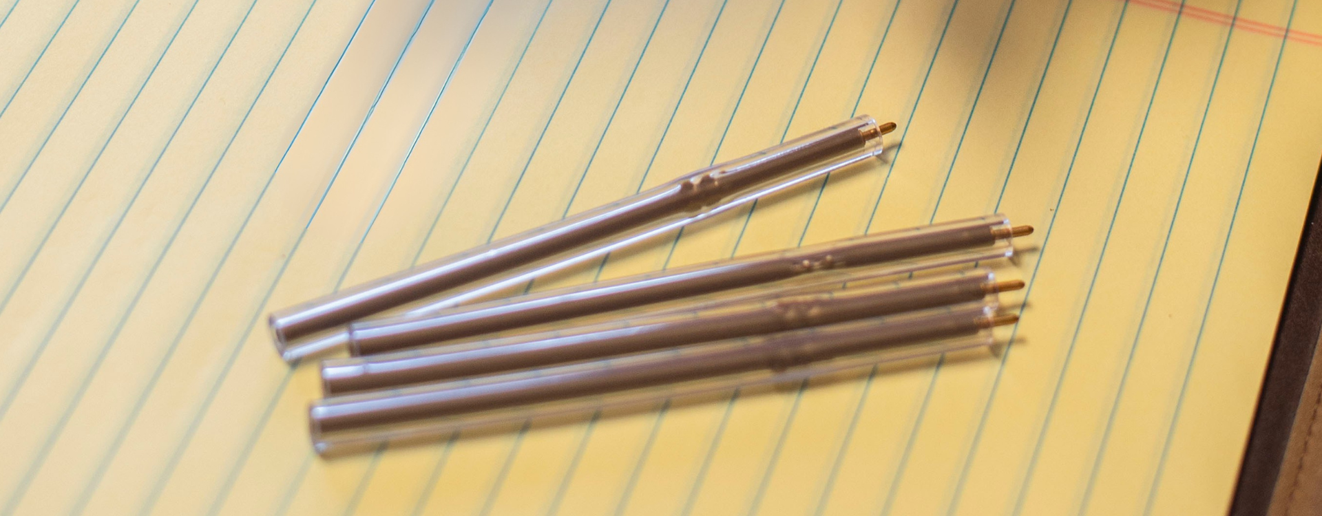 Collection of non lethal flexible pens on a piece of lined paper