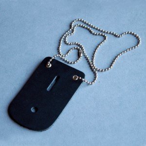 Black dog tag with chain on a light blue background