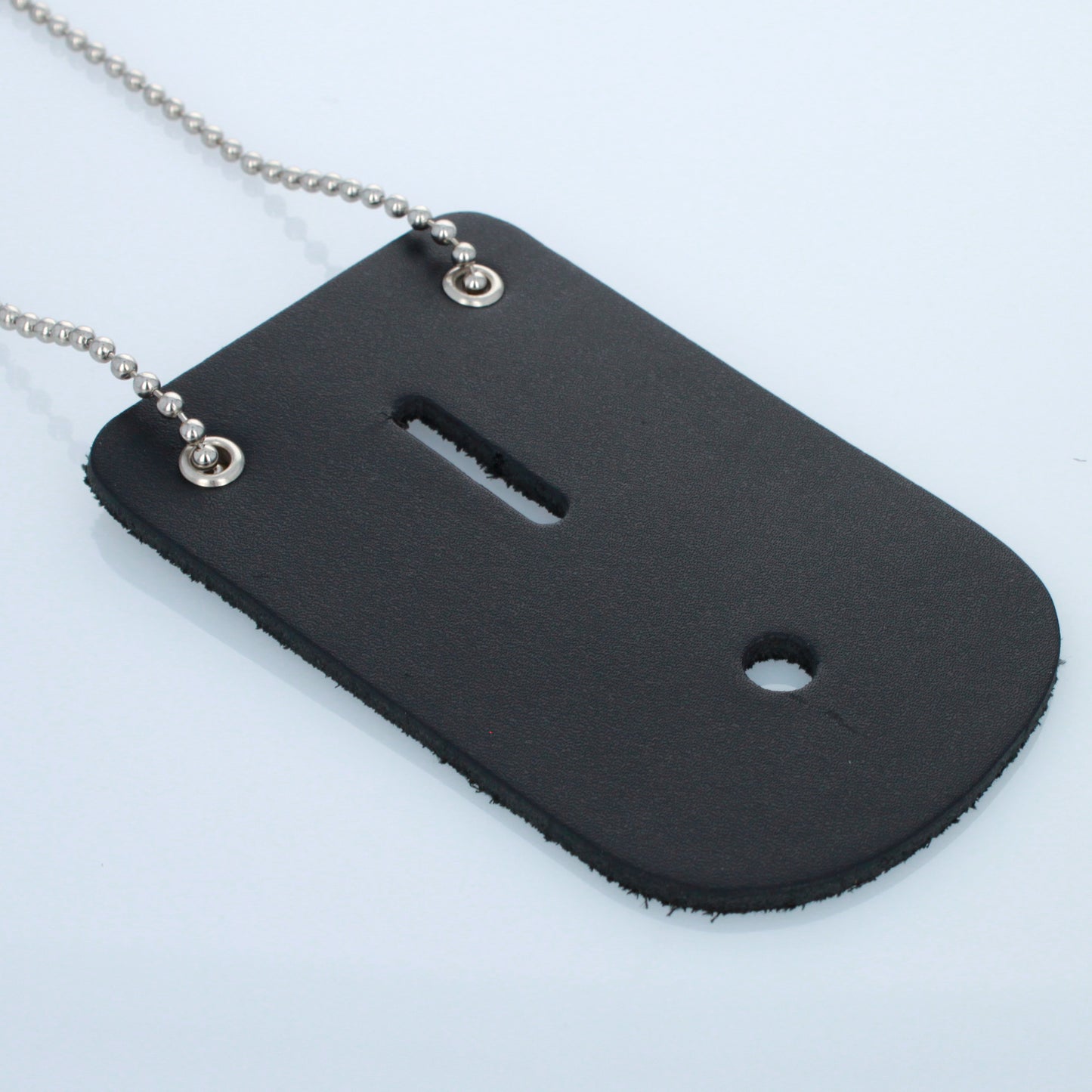 Angled view of black leather badge holder with metal grommets and chain.