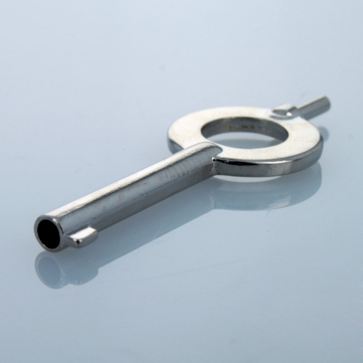Angled view of stainless steel universal handcuff key.