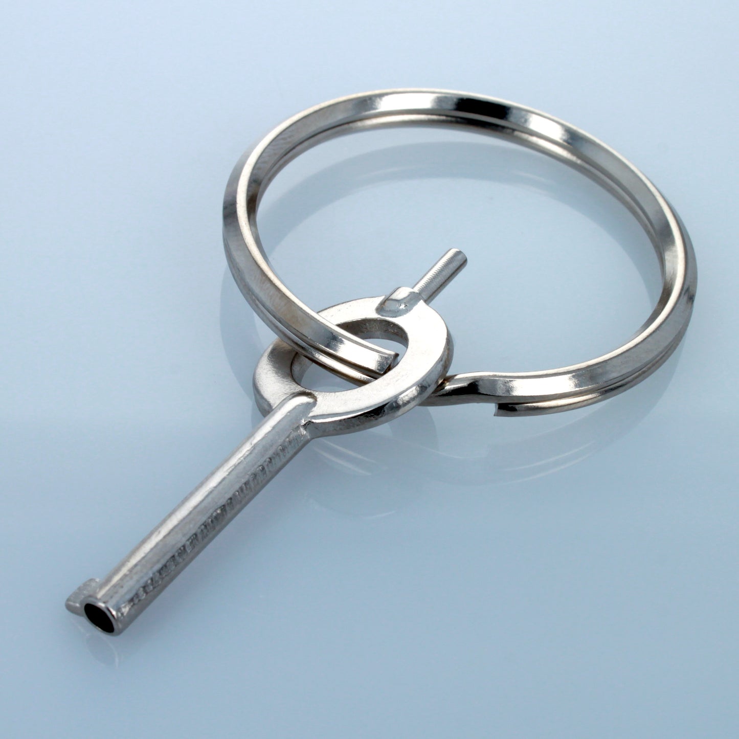 Stainless steel universal handcuff key with keyring attached.