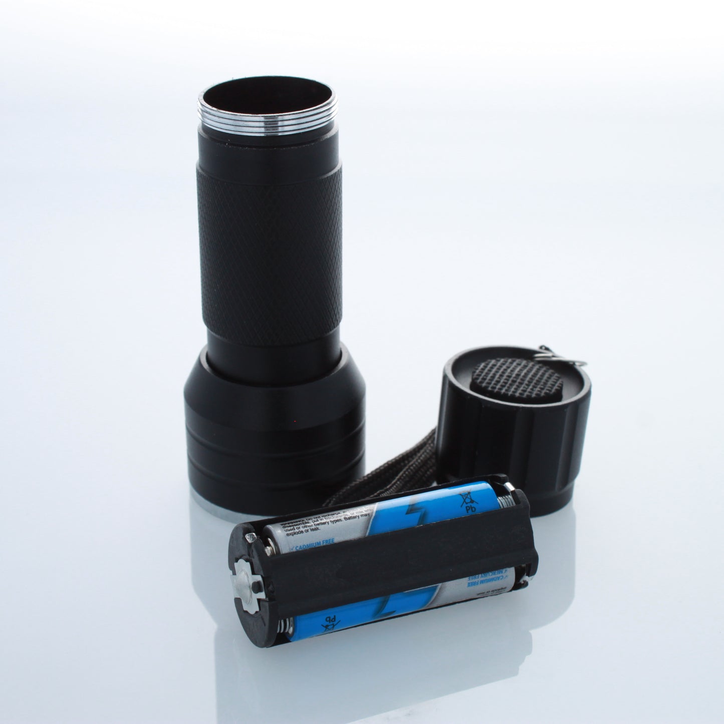 Open UV LED flashlight showing battery compartment and three AAA batteries.