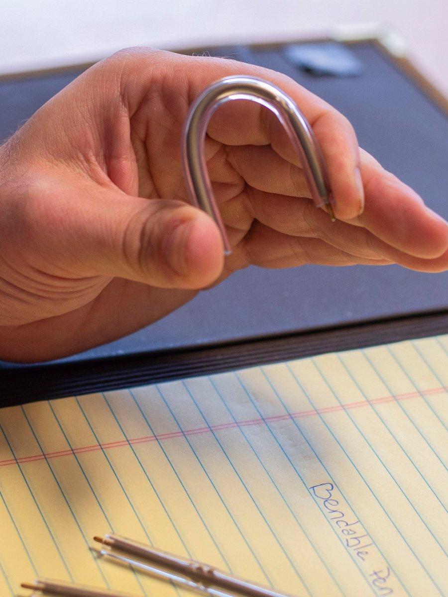 non lethal flexible pens shown over notepad with person holding the writing utensil