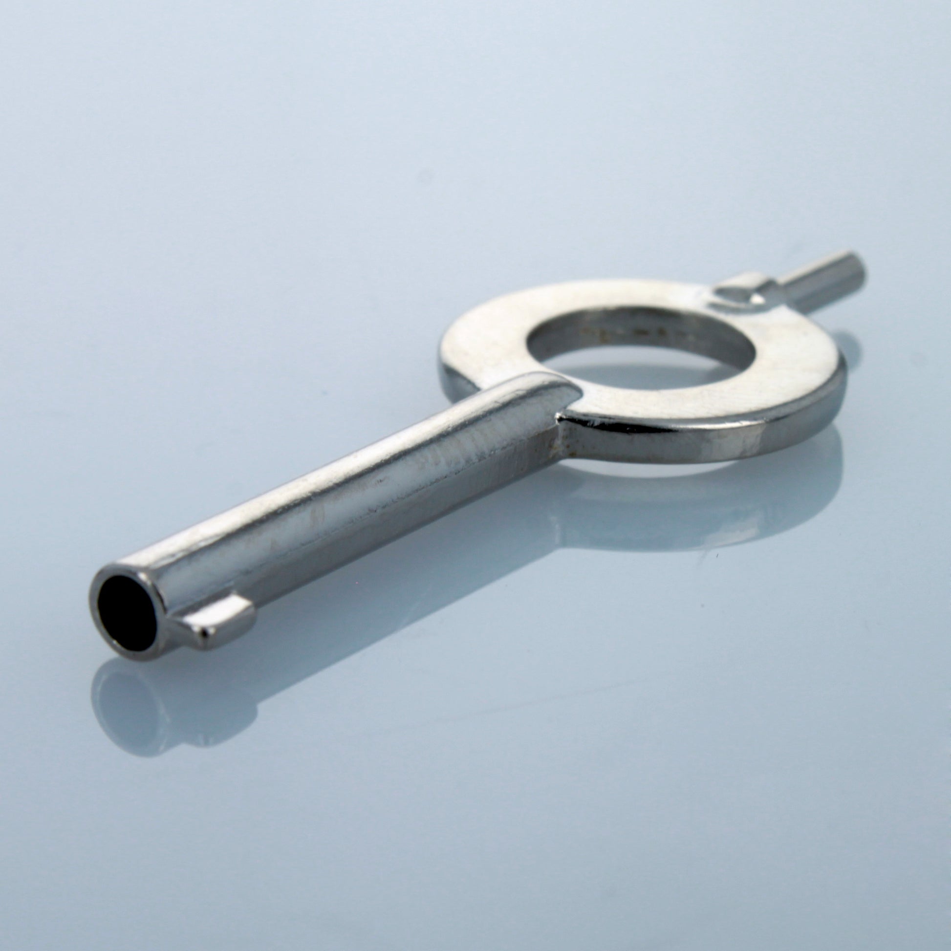 Angled view of stainless steel universal handcuff key.